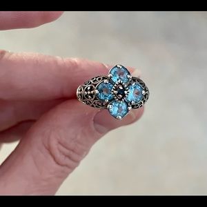 Blue topaz with small sapphire chip set in scrollwork sterling silver